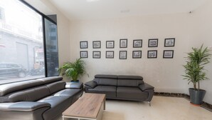 Ein modernes Wohnzimmer mit zwei Sofas, einem Couchtisch und gerahmten Bildern an der Wand.
