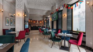 A hotel lobby with a high ceiling featuring intricate patterns, a reception desk, and a seating area with tables and chairs. - Olympic Inn Casablanca (Casablanca)