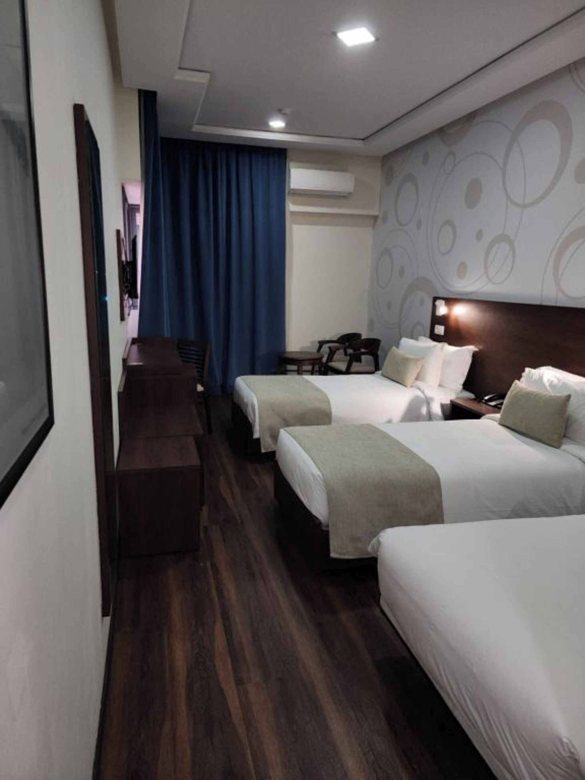 Hotellihuone, jossa on kaksi sänkyä, työpöytä ja tuoli.