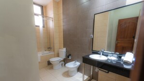 Ein modernes Badezimmer mit Badewanne, Toilette, Bidet und Waschbecken.