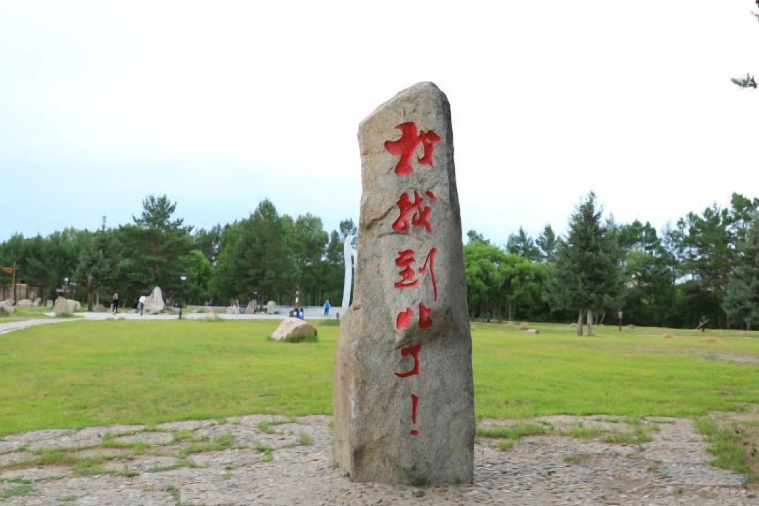 Un monument de pierre orné de sculptures et d’inscriptions, situé dans un parc.
