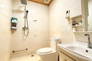 Un baño con inodoro, lavamanos y ducha.