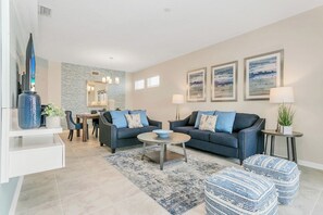 Un salon moderne avec un canapé, une table basse et un téléviseur.