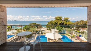 A balcony with a clear view of a swimming pool, lounge chairs, and a glass table. - Villa Calla ZadarVillas (Petrcane)