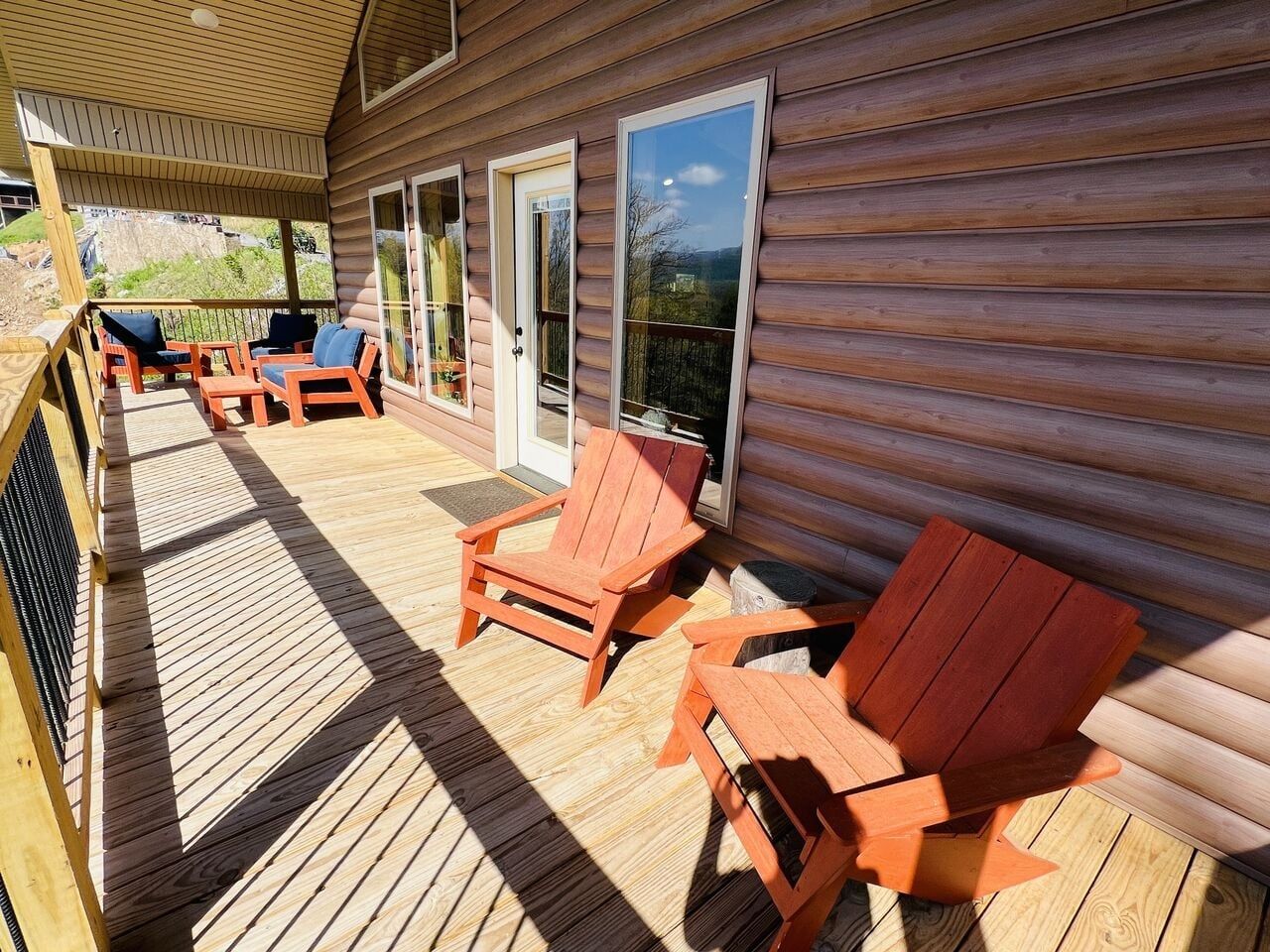 A wooden deck with outdoor seating and a view of a natural landscape.