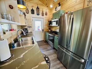 Een keuken met roestvrijstalen apparatuur, een spoelbak en houten wanden.