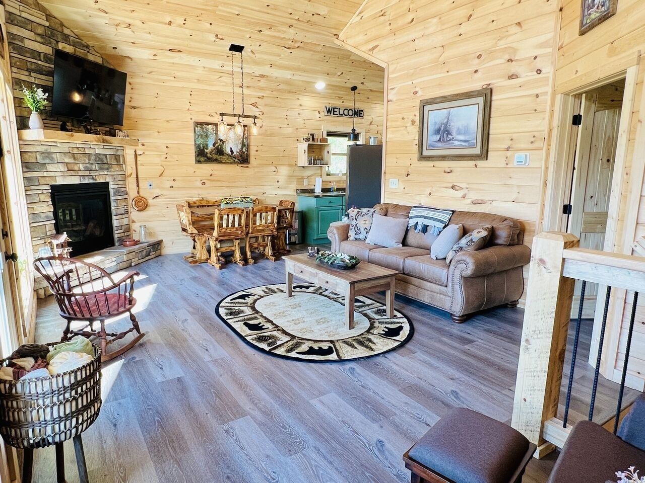 A wooden interior with a fireplace, a sofa, a coffee table, and a dining area.