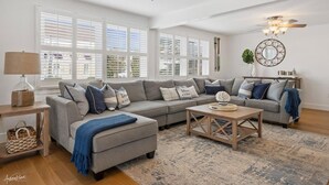 A living room with a sectional sofa, a coffee table, and a chandelier. - Seaside Serenity - Stone Harbor, NJ (Stone Harbor)