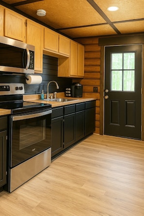 A kitchen with wooden cabinets, stainless steel appliances, and a black door.