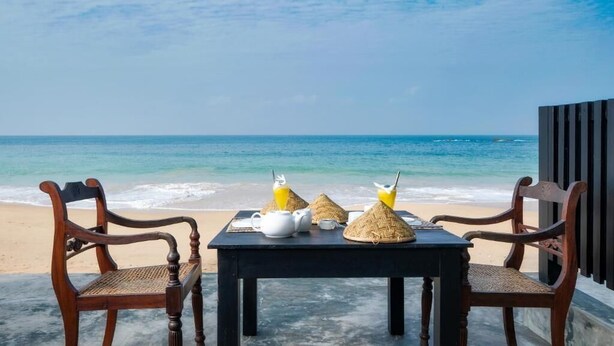 Une table avec des chaises et une vue sur l’océan.