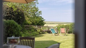 A patio with a table, chairs, and a view of the countryside. - Lovely 2-bed Cottage in St Brides, Pembrokeshire (Haverfordwest)