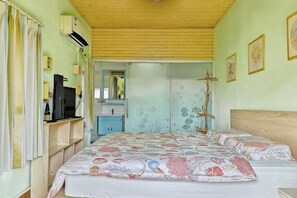 A bedroom with a bed, a dresser, a mirror, and a wall with marine-themed artwork. - Lane Cottage B&B (Zhuhai)