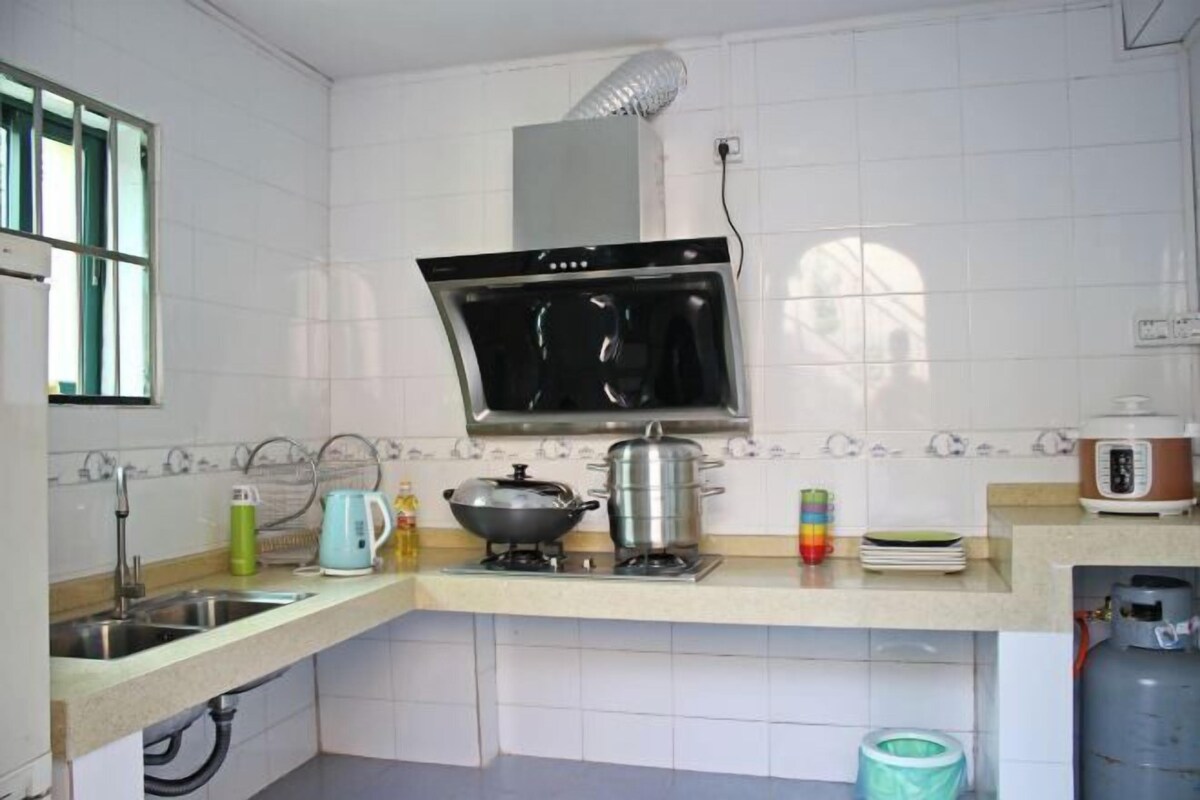 A kitchen with a stove, sink, and a window.