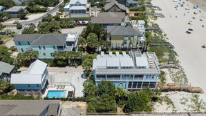 An aerial view of a coastal residential area with houses, a swimming pool, and a beach. - Sip by the Pool - One bedroom, Pool, Beach Access (Pawleys Island)