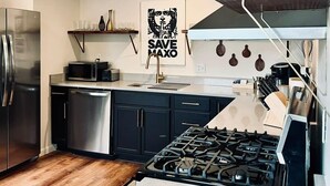 Una cocina moderna con electrodomésticos de acero inoxidable, estufa a gas y microondas.
