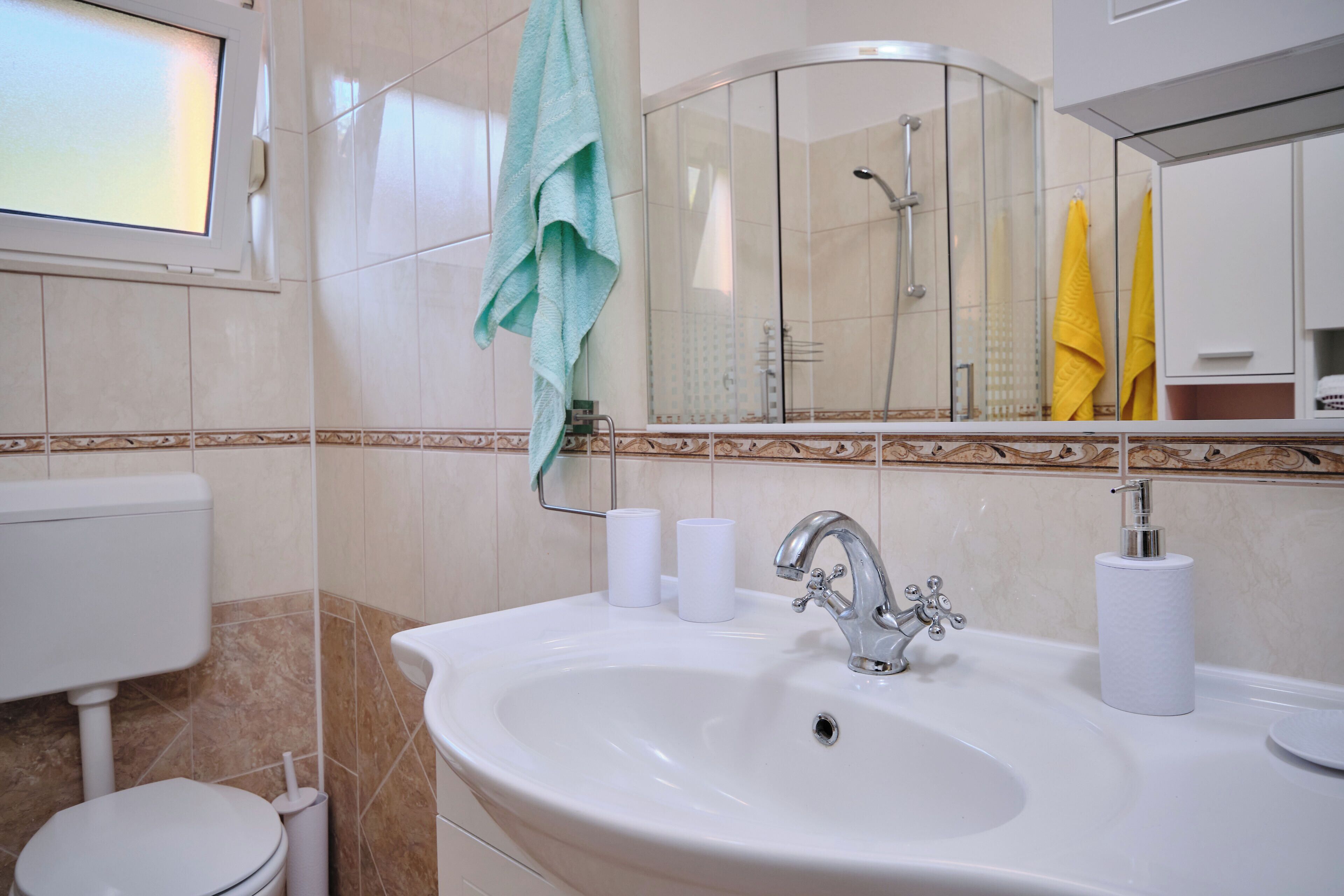 Un baño con lavamanos, inodoro y ducha.