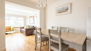 A dining area with a wooden table and chairs, a chandelier, and a framed picture on the wall. - Smugglers' Gait | Anstruther (Anstruther)