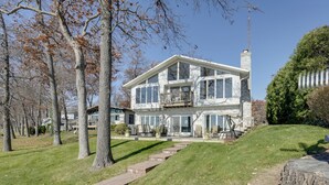 Une maison à deux étages dotée d’un grand balcon, d’une cheminée et d’une pelouse bien entretenue.