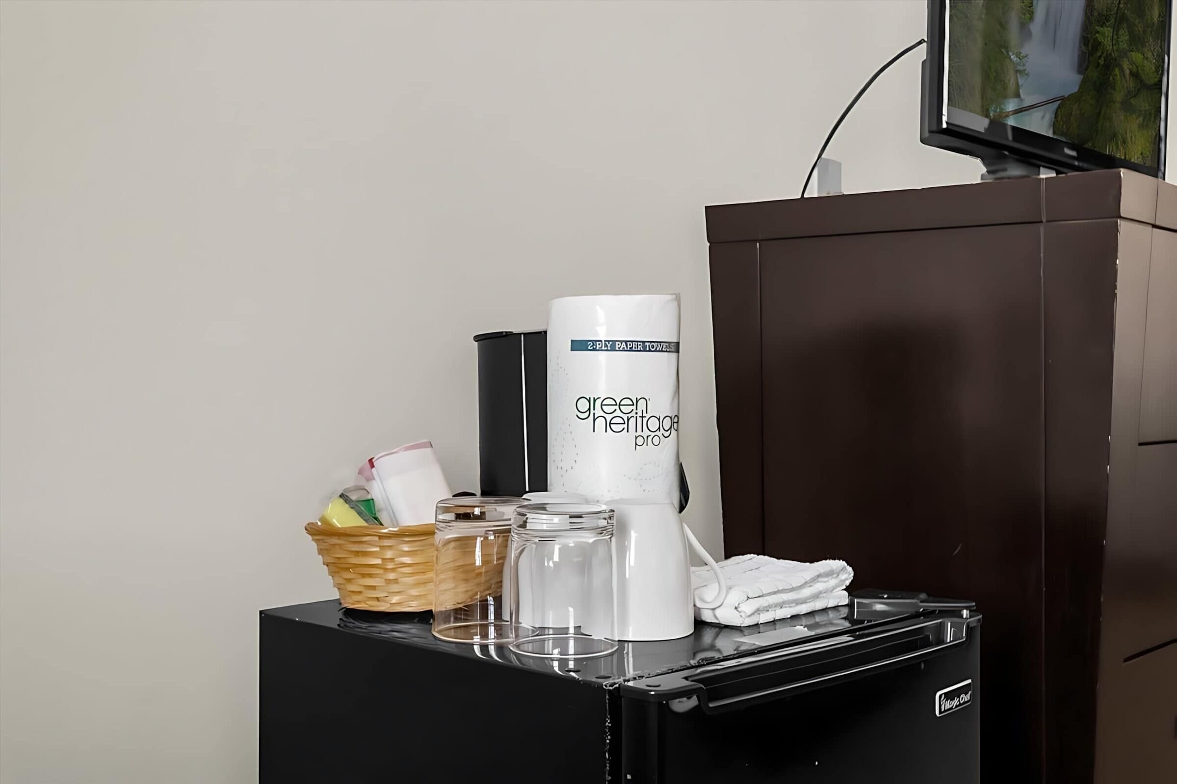 A coffee station with a coffee maker, a basket, and glass containers.