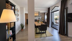 A modern living room with a dining area, a kitchen in the background, and a large window with curtains. - 3 minutes from the sea! Florami apartment. Pet-Friendly! (Kaštel Stari)