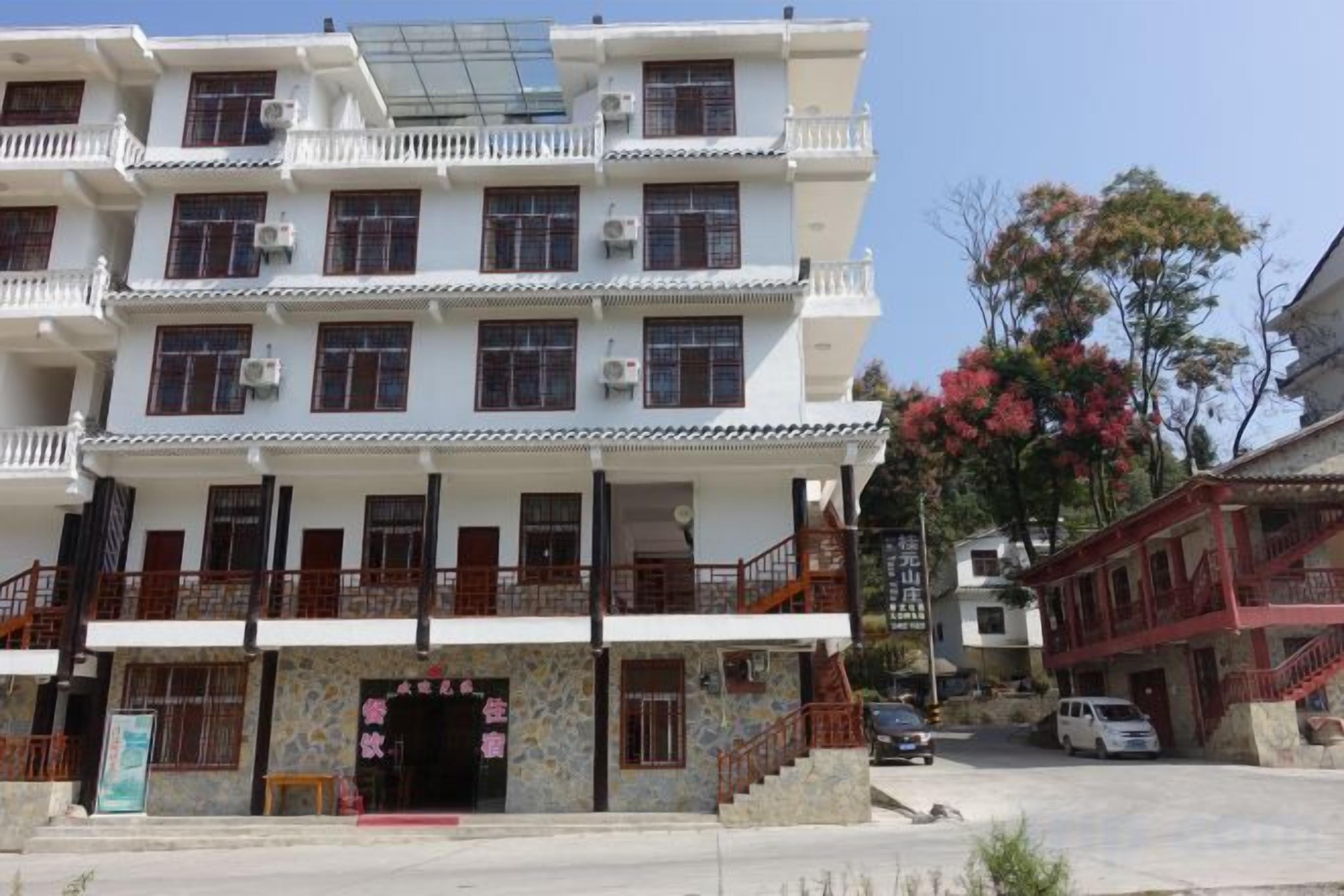 A multi-story building with a traditional architectural style, featuring balconies and a central entrance with a decorative archway.