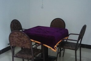A dining table with a purple tablecloth, surrounded by four chairs with patterned upholstery. - Guiyuan Villa (Enshi City)