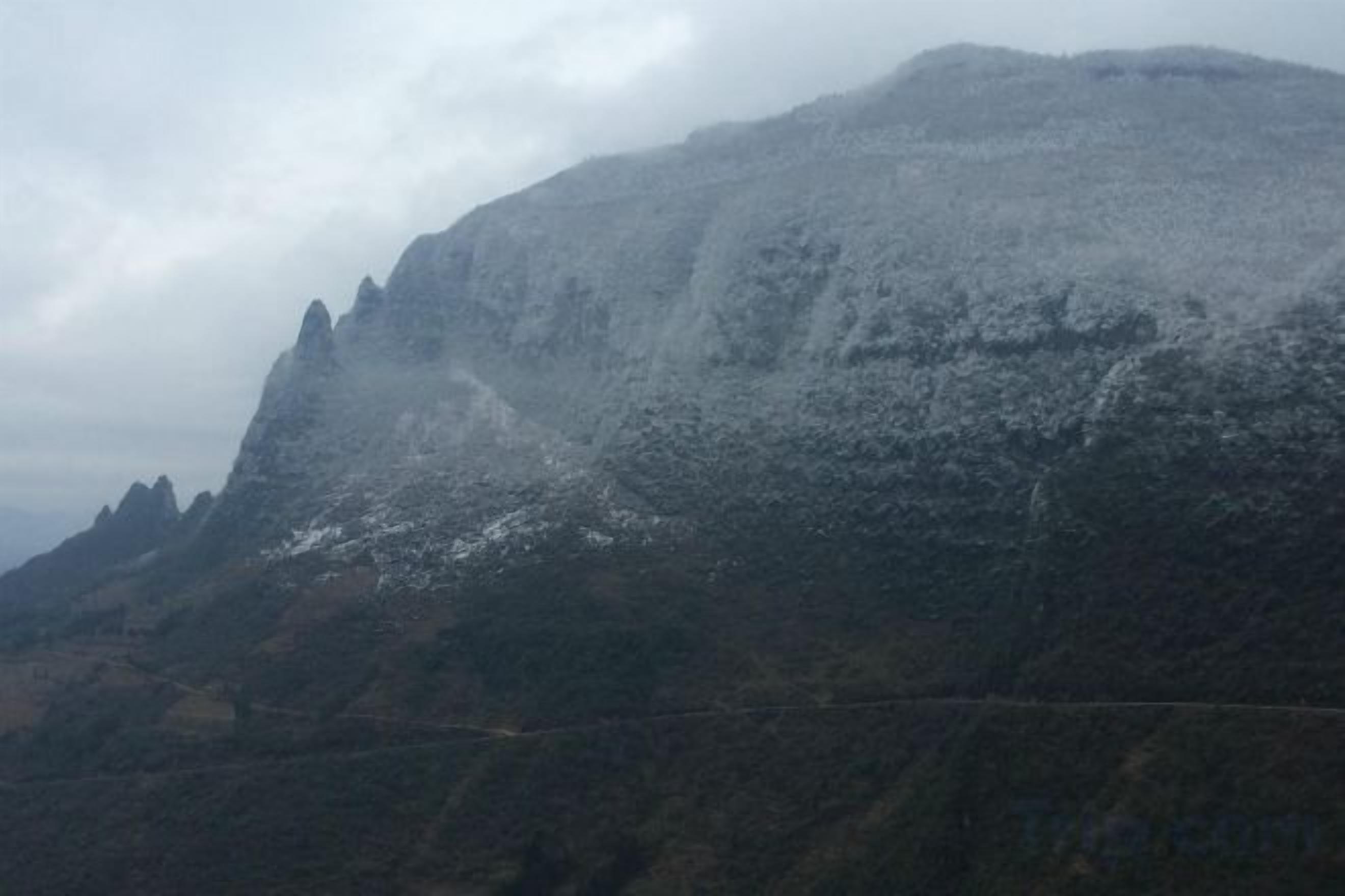 A mountain with a rugged terrain and a clear sky.