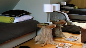 Ein gemütliches Zimmer mit Schlafkoje, zwei Holzschemeln und einer Lampe.