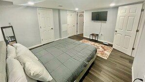 Une chambre à coucher avec un lit, une télévision et une porte.