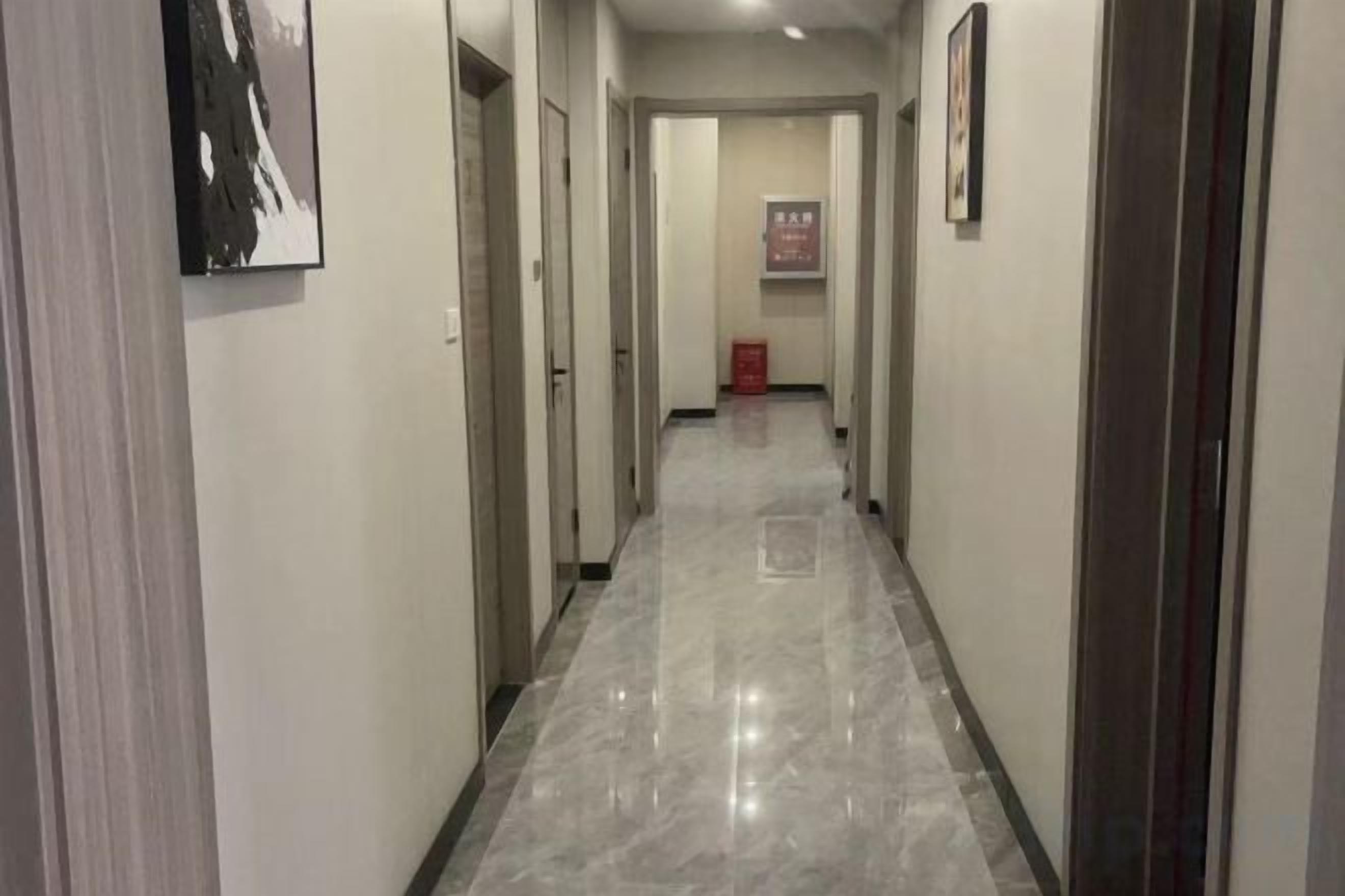 Un pasillo con puertas a ambos lados, que conduce a habitaciones.