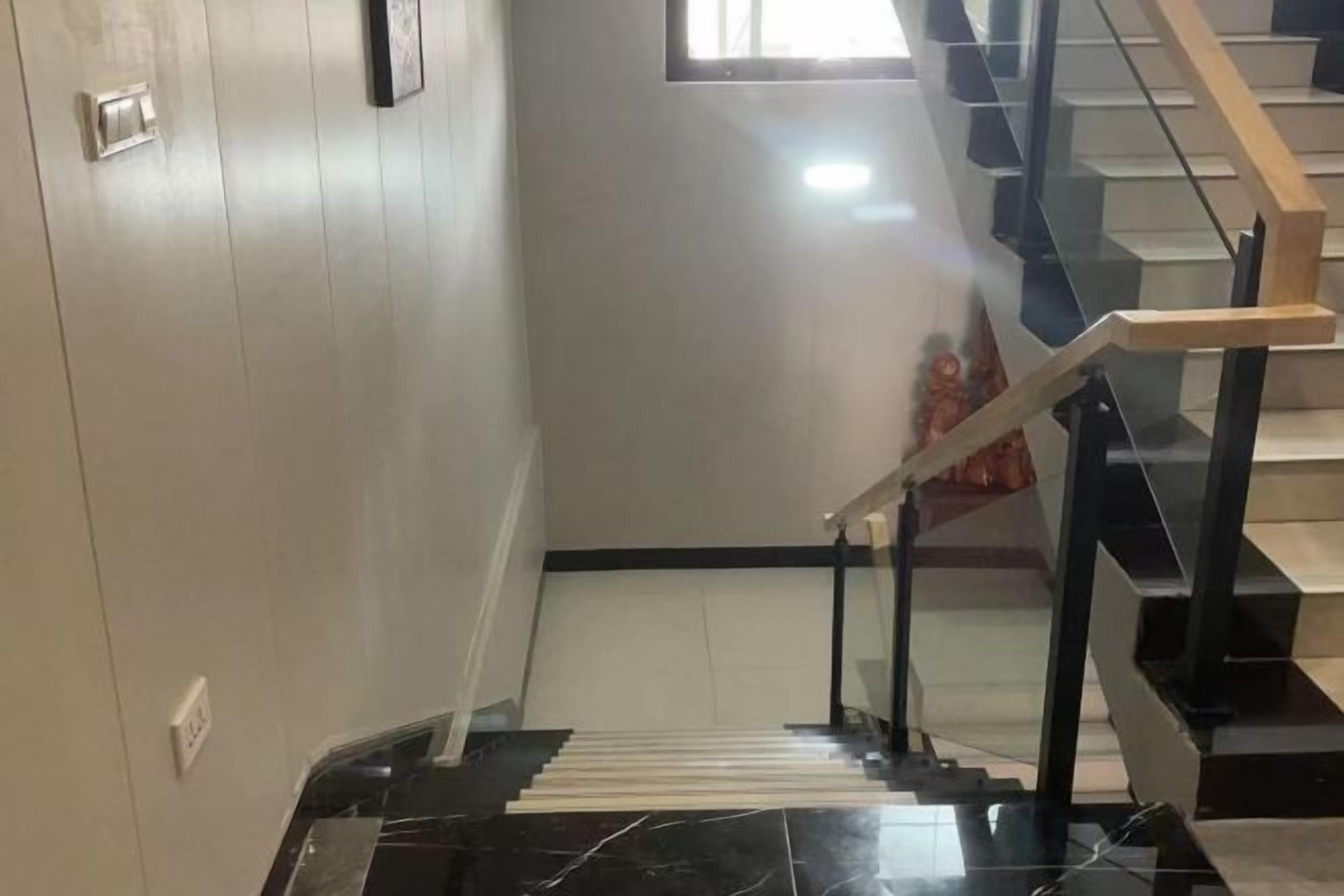 Una escalera con barandilla y protección de vidrio, que conduce a un piso superior.