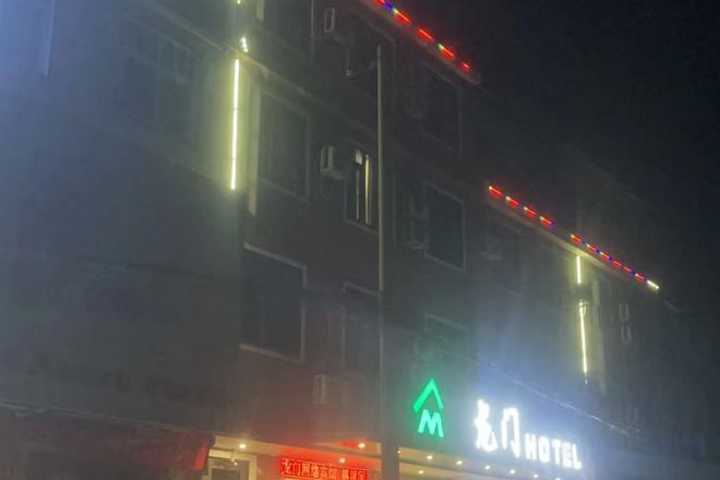 Un edificio de varios pisos con letreros iluminados para un hotel y un restaurante.