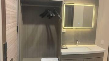 Een moderne badkamer met een inloopdouche, een wastafel met spiegel en een handdoekrek.