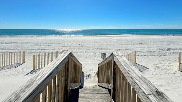 A wooden boardwalk leading to a sandy beach with a clear blue sky. - Steps to the beach and Dock on the Bay! Pool, family and pet friendly! (Gulf Shores)