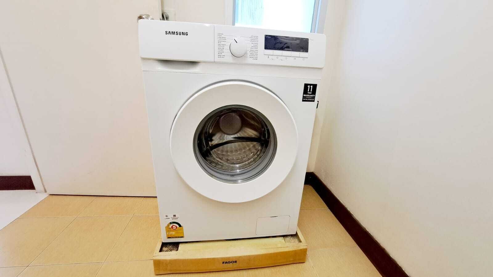 Màquina rentadora Samsung blanca amb un panell de control i un adhesiu de garantia.