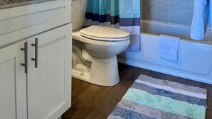 Ein Badezimmer mit Toilette, Waschbecken und Badewanne.