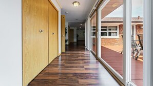 A hallway with wooden doors and a view of a brick building outside. - Fairlawn 327 | 6 BR • 2F & 4H Bathrooms (Fairlawn)