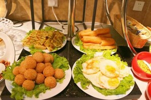 A buffet with various food items including fried balls, eggs, and bread. - New Baihui Boutique Hotel (Jining)