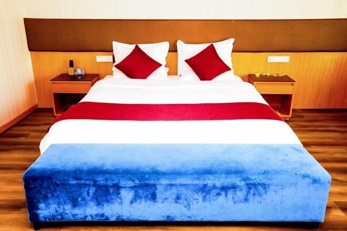 A hotel room with a bed, two nightstands, and a wooden headboard.