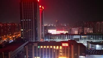 A hotel with a prominent sign, surrounded by high-rise buildings and city lights.