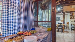 A breakfast buffet with various food items and a large window with curtains. - Villa Rubcic (Rakovica)