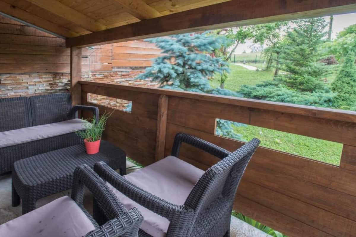 An outdoor patio with wicker furniture and a wooden fence.