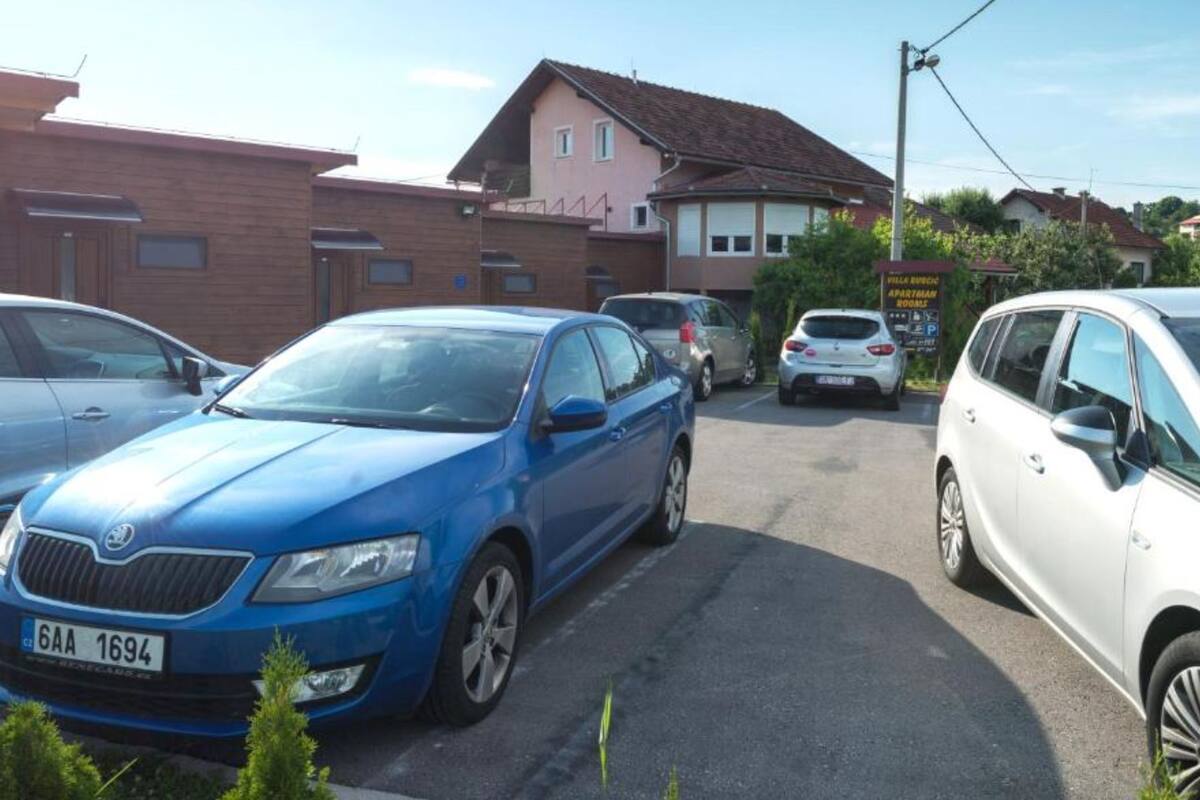 A parking lot with several cars, including a blue sedan and a white SUV.