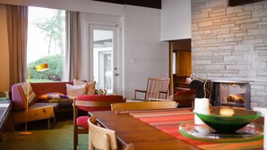 Un salon chaleureux avec une cheminée, une table à manger en bois et des sièges confortables.