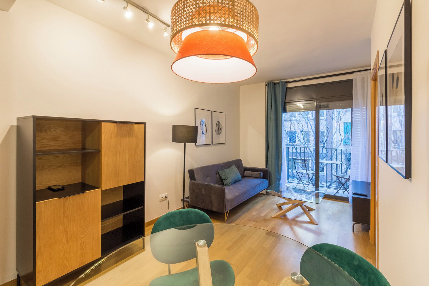 A modern living room with a sofa, a glass coffee table, and a wooden cabinet.
