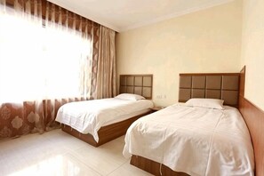 A hotel room with two beds, a large window with curtains, and a tiled floor. - Qian Guoxin Dingsheng Hotel (Songyuan)