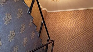 A staircase with ornate wall patterns and a metal handrail. - Qian Guoxin Dingsheng Hotel (Songyuan)