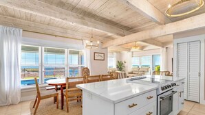 A modern kitchen with a central island, white cabinetry, and a large oven. - Starfish Wishes: Beachfront Duplex Unit, Great location, remodeled, Pet Friendly (St. George Island)