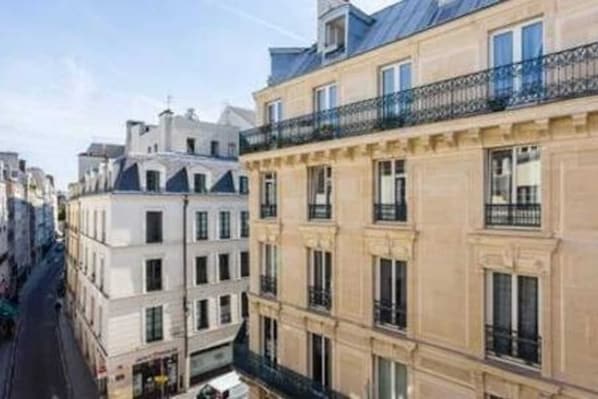 A multi-story building with a classic architectural style, featuring balconies and large windows.