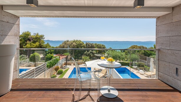 A balcony with a clear view of a swimming pool and a scenic landscape. - Villa Magnolia Zadarvillas (Zadar)